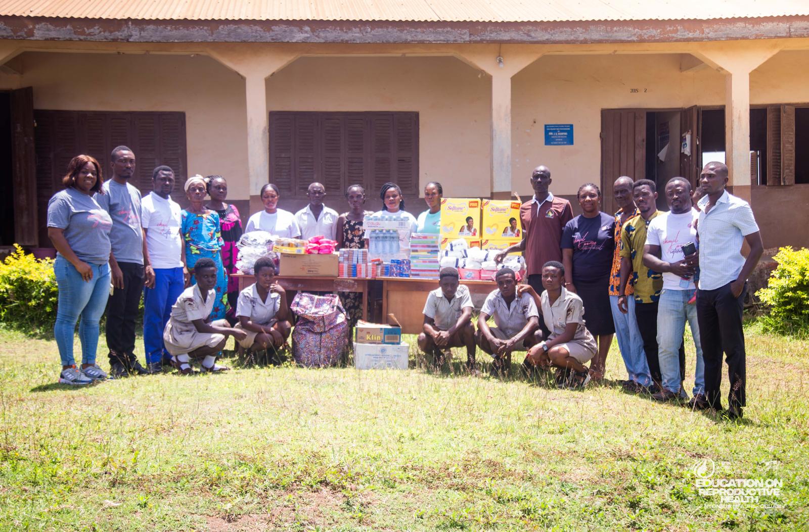 CHAYIL team and pupils standing behind a table of donated school and hygiene supplies