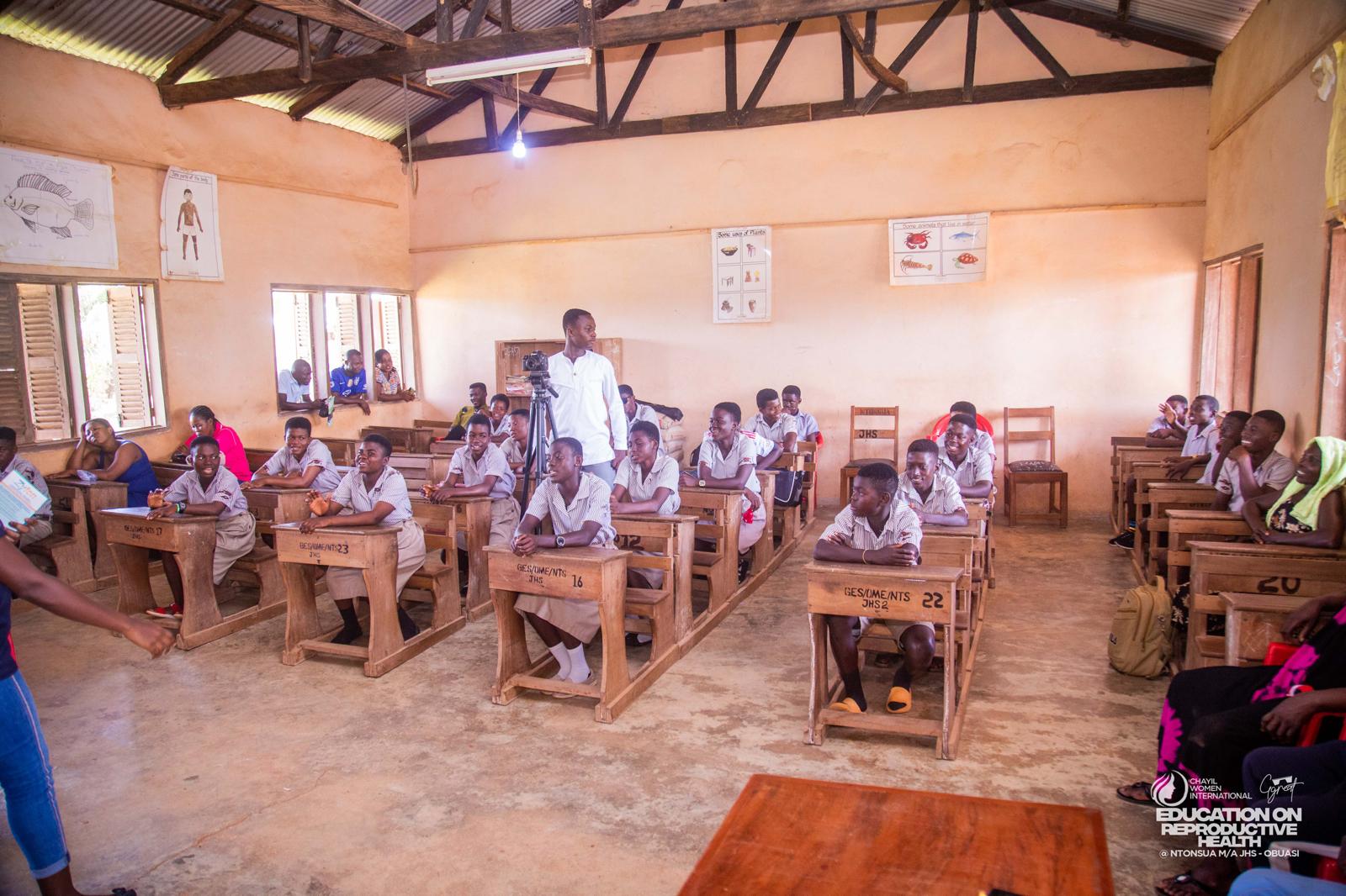 Pupils seated at wooden desks during a CHAYIL classroom session