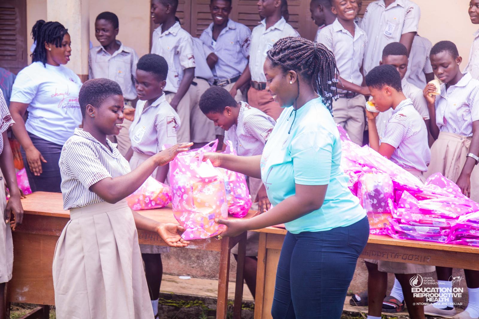 A CHAYIL volunteer handing a donation bag to a pupil at a school outreach